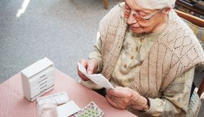 Gesundheit - Foto einer alten Frau bei Medikamenteneinnahme